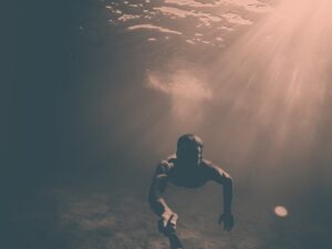 Diver taking a selfie while swimming underwater using a GoPro