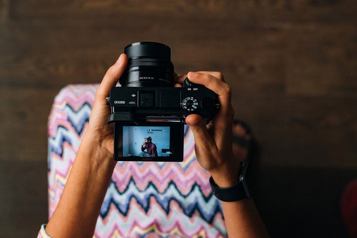 A mirrorless camera being used with a flip screen