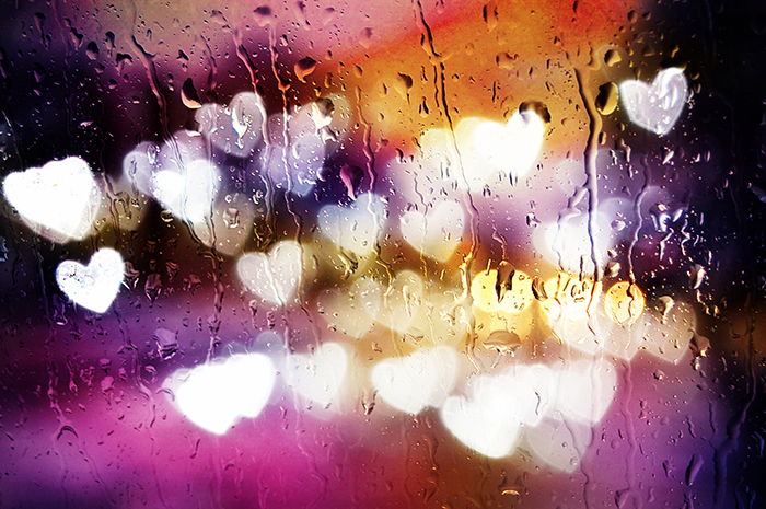 Custom bokeh blur with heart behind a wet window.