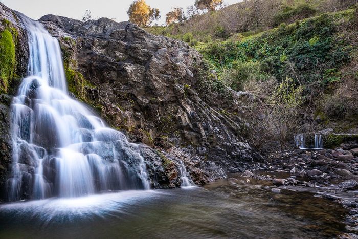 daytime long exposure photo of a small waterfall