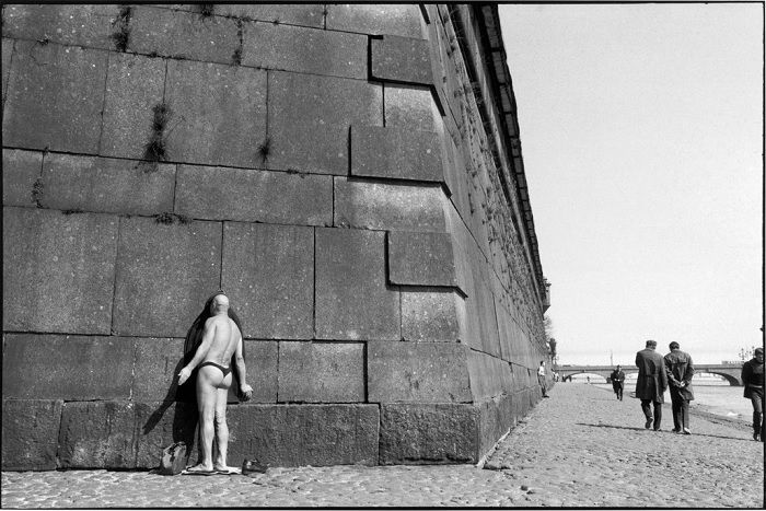 Man in thong facing a wall