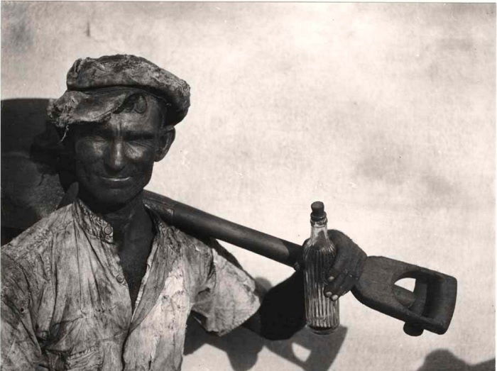 Man with shovel and bottle of beer