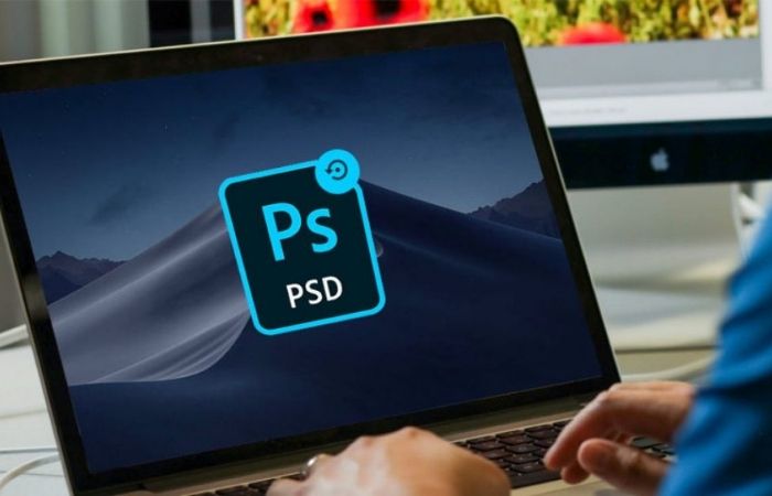 an image of a man on his laptop with photoshop logo on the screen