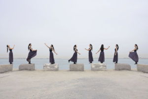 Same woman cloning standing on the bricks posing on the beach ov