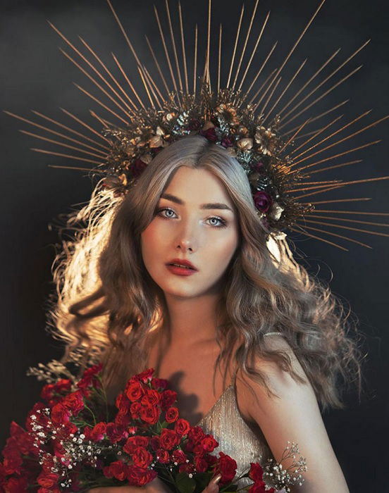 portrait of a woman with spiky crown holding flowers