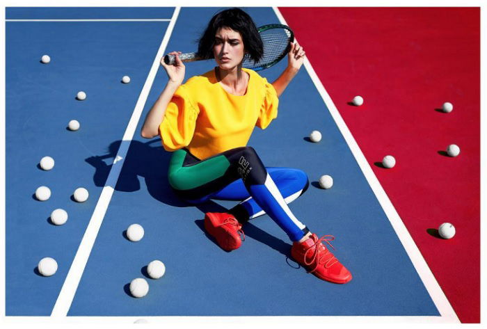 Woman in colorful clothes sitting on a tennis court