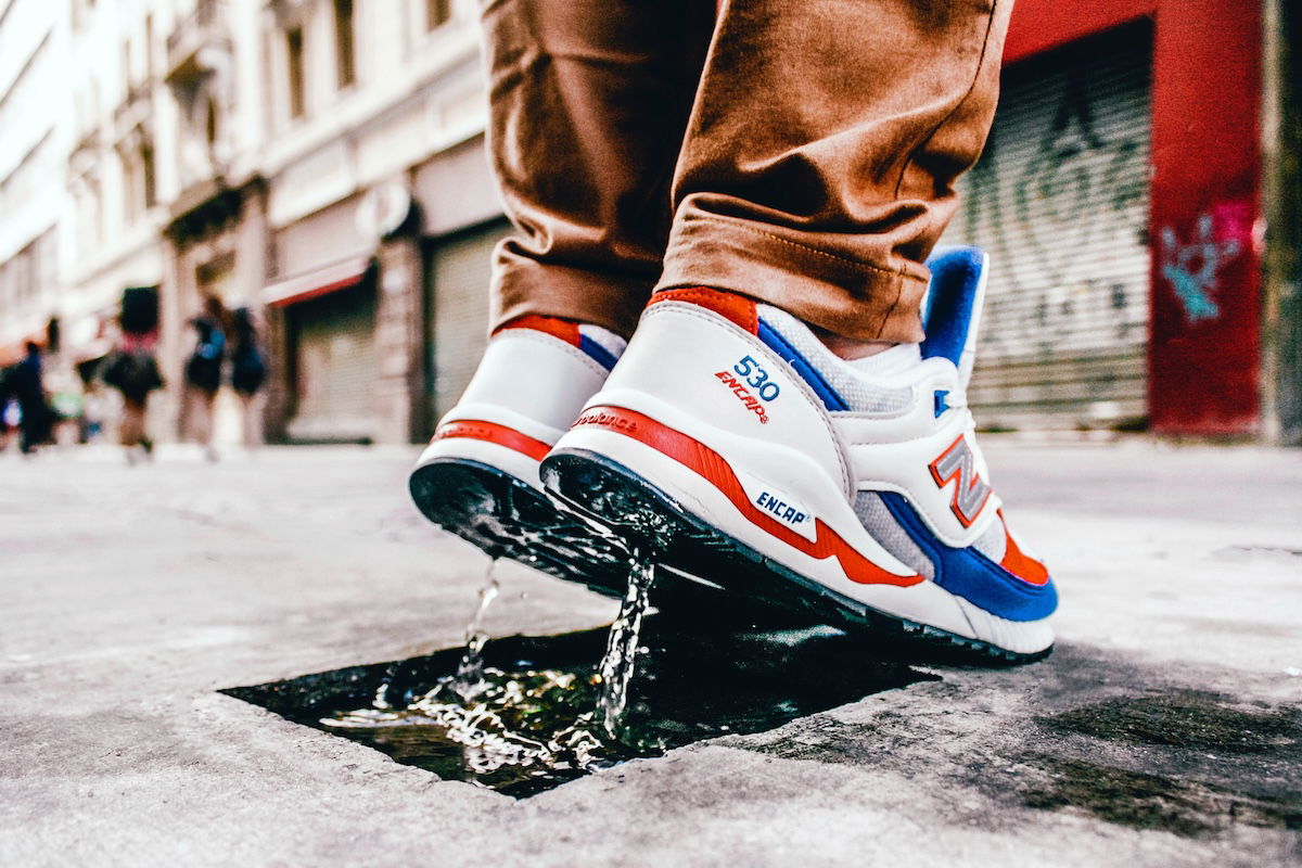 Close-up of shoes splashing water with a person just starting to jump up