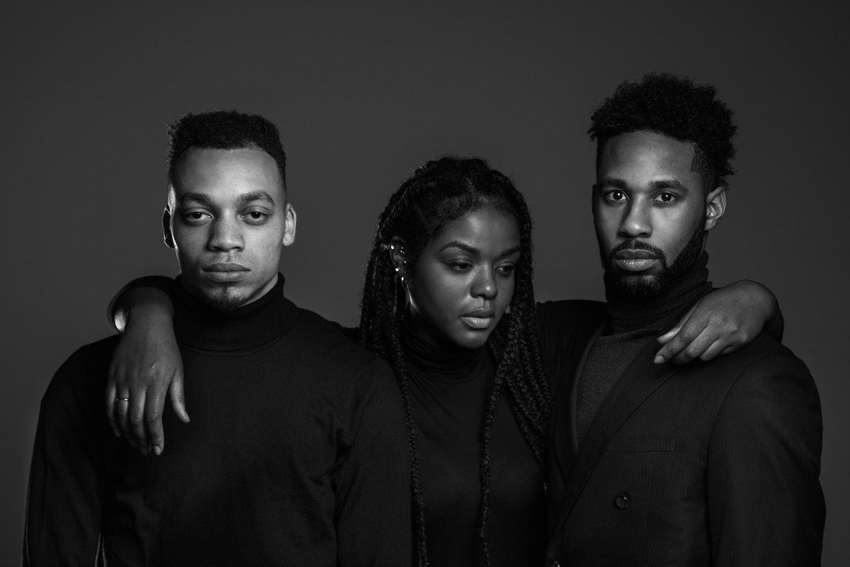 Black-and-white studio group portrait of three people