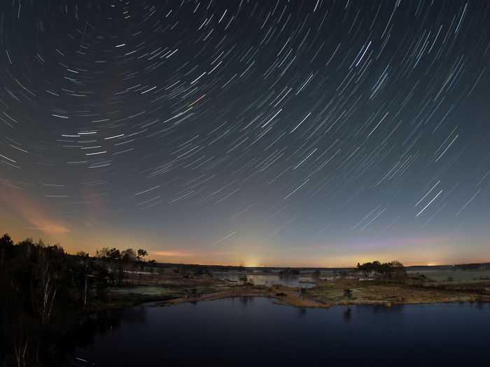 circular star trails above a lake after editing