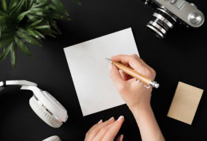 Top view of a flat lay female hand writes a note