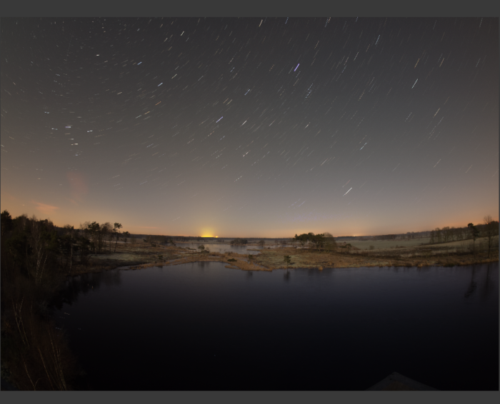 star trails above a lake 